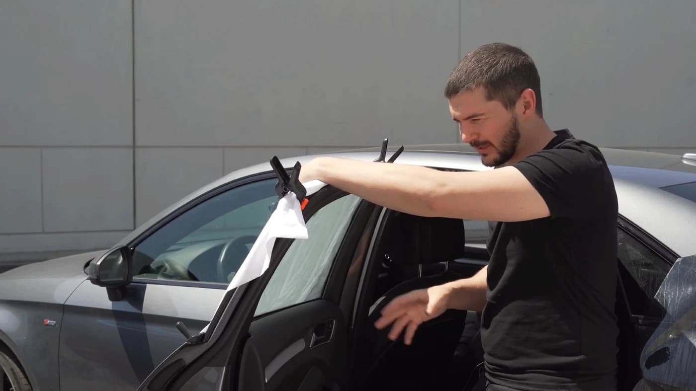 Elliot demonstrating a window installation during a mobile tinting lesson