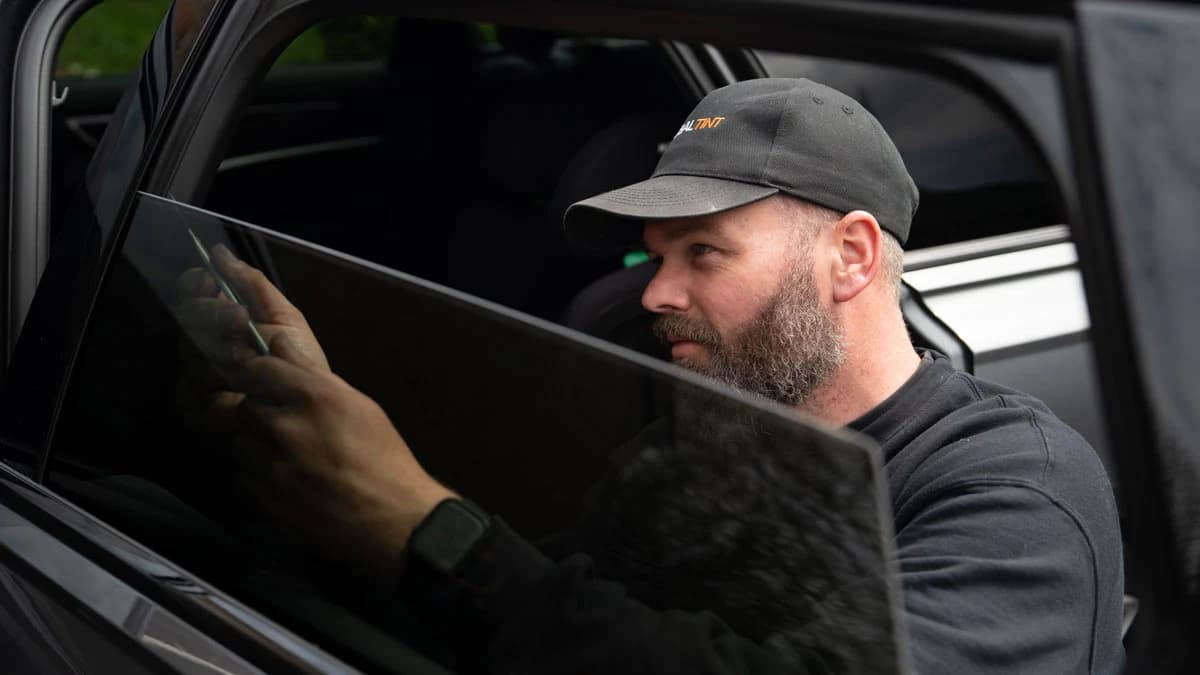 Global Tint installer fitting tint film to a car side window